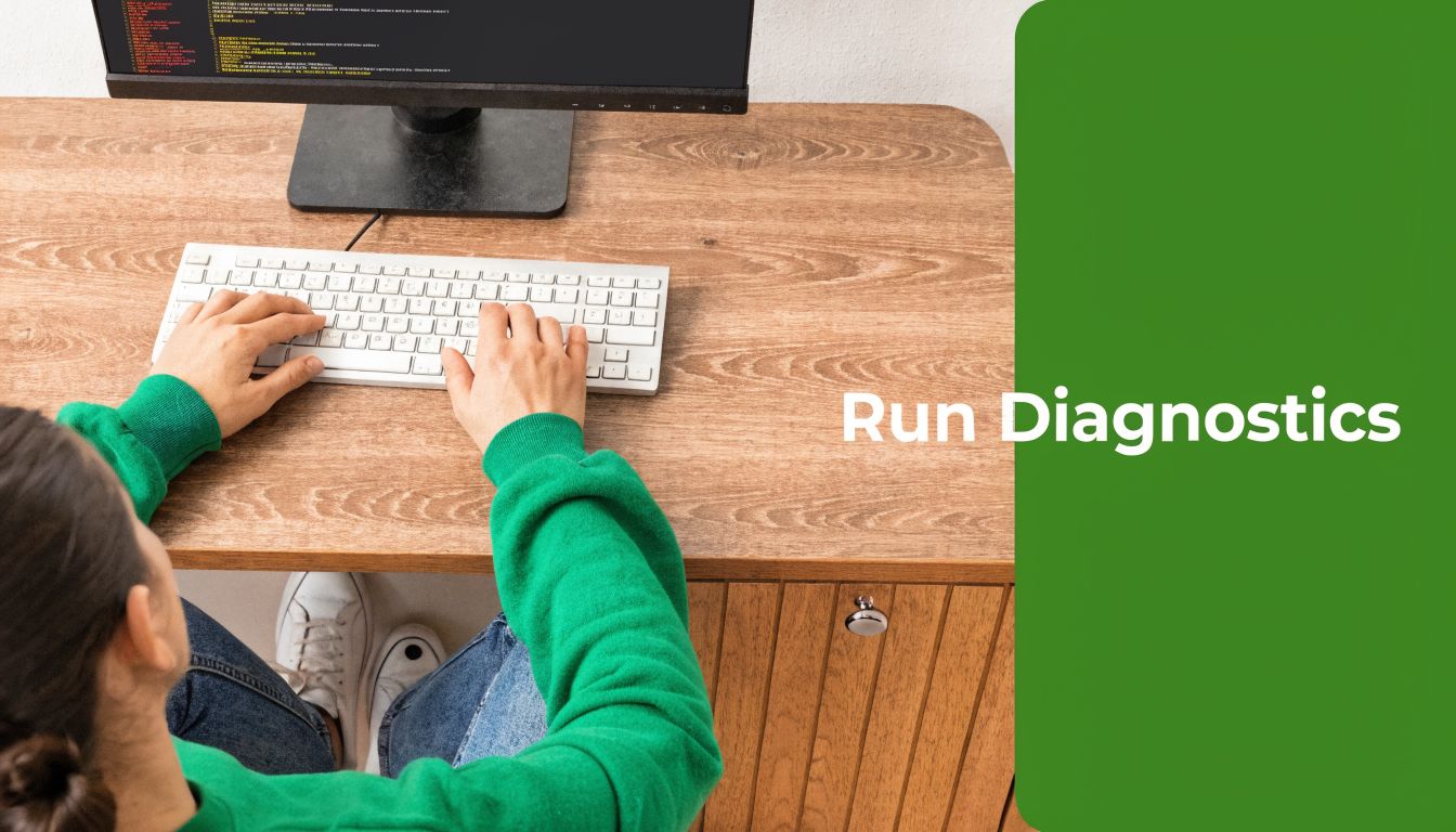 A person wearing a green sweater working on a computer and running diagnostics on their desk.