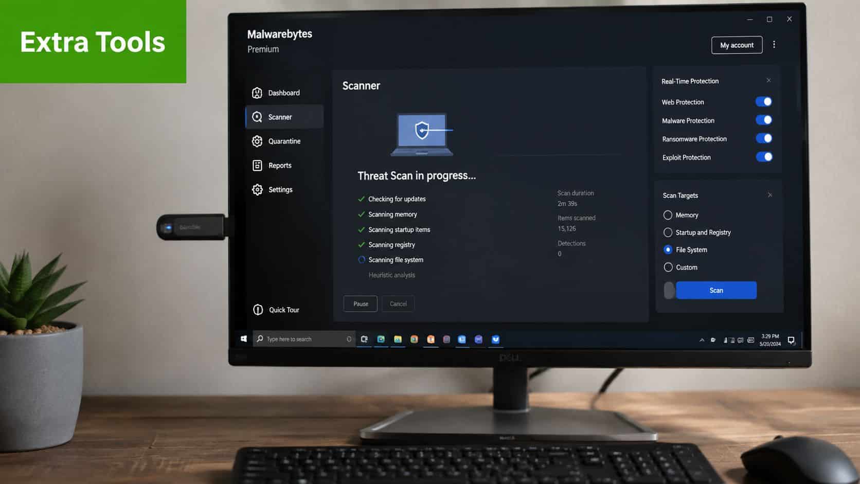 A computer screen displaying a Malwarebytes threat scan in progress on a desktop setup with a keyboard.